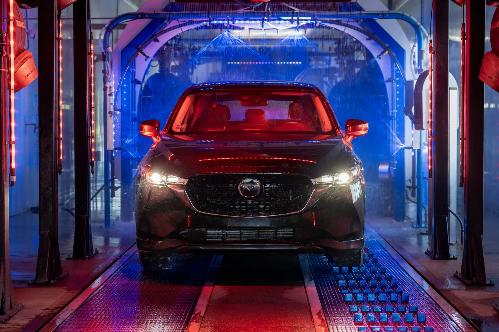 A car being cleaned inside a Jilly's Car Wash tunnel, with its features called out